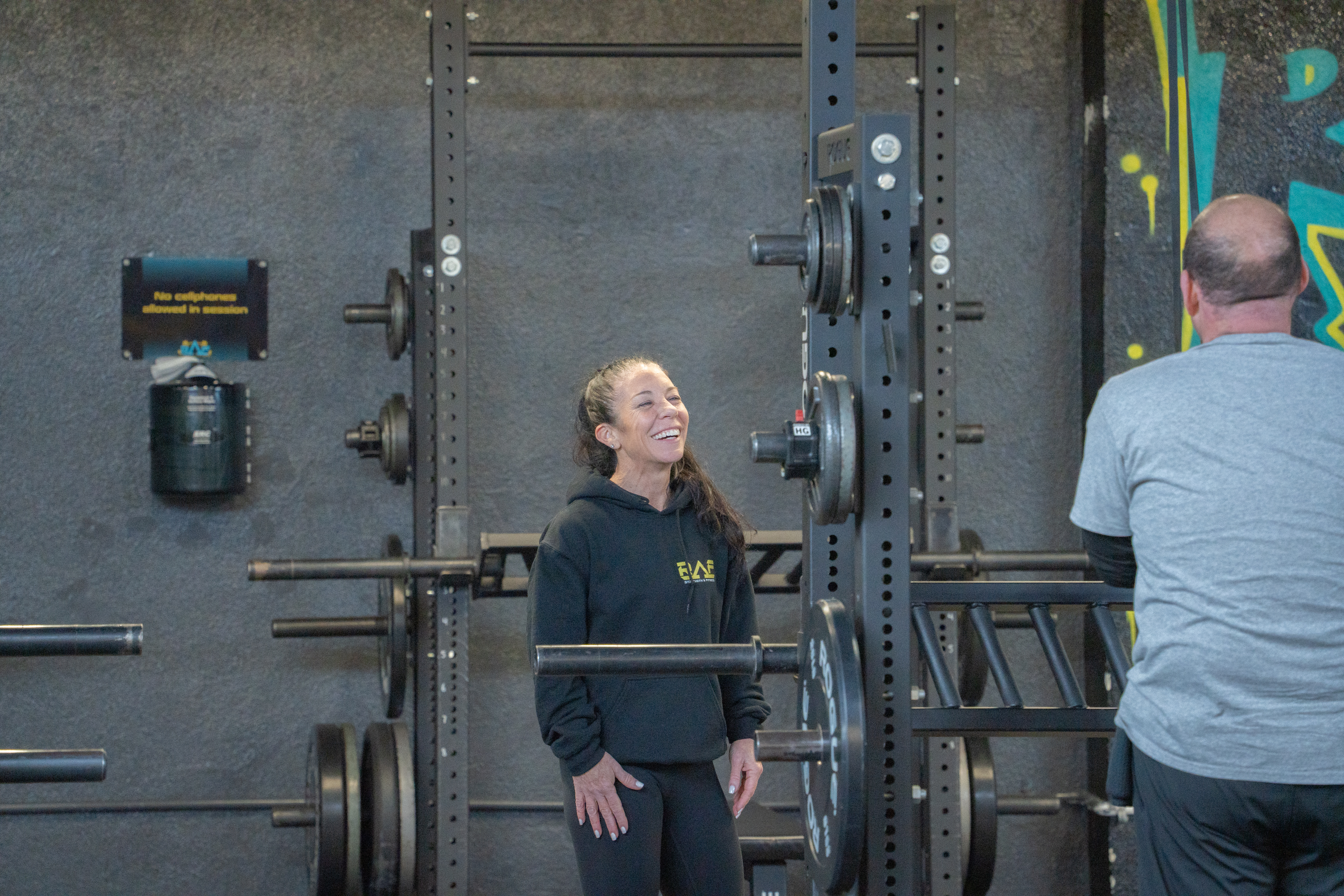Coach helping member with personalized strength training at RAF gym